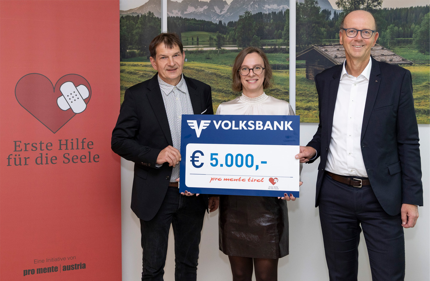 Spendenschek in Höhe von 5000 Euro wird von Volksbank Vorstand Martin Holzer an einen Mann und eine Frau von ProMente übergeben.