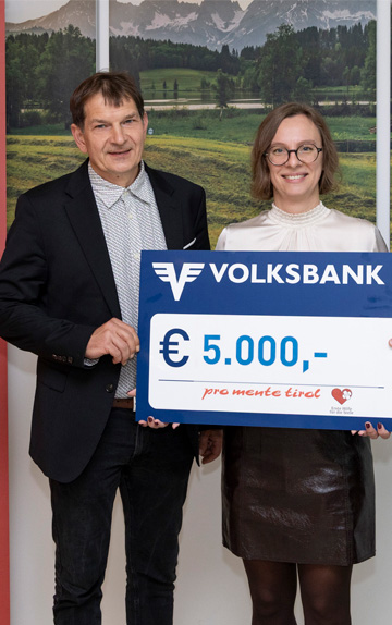 Ein Mann und eine Frau halten einen Spendenscheck.