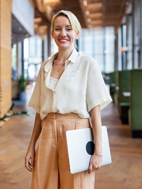 Frau mit Laptop in der Hand.