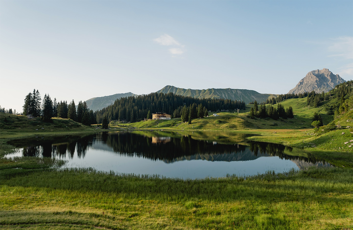 Eine grüne Berglandschaft mit See in der Mitte.